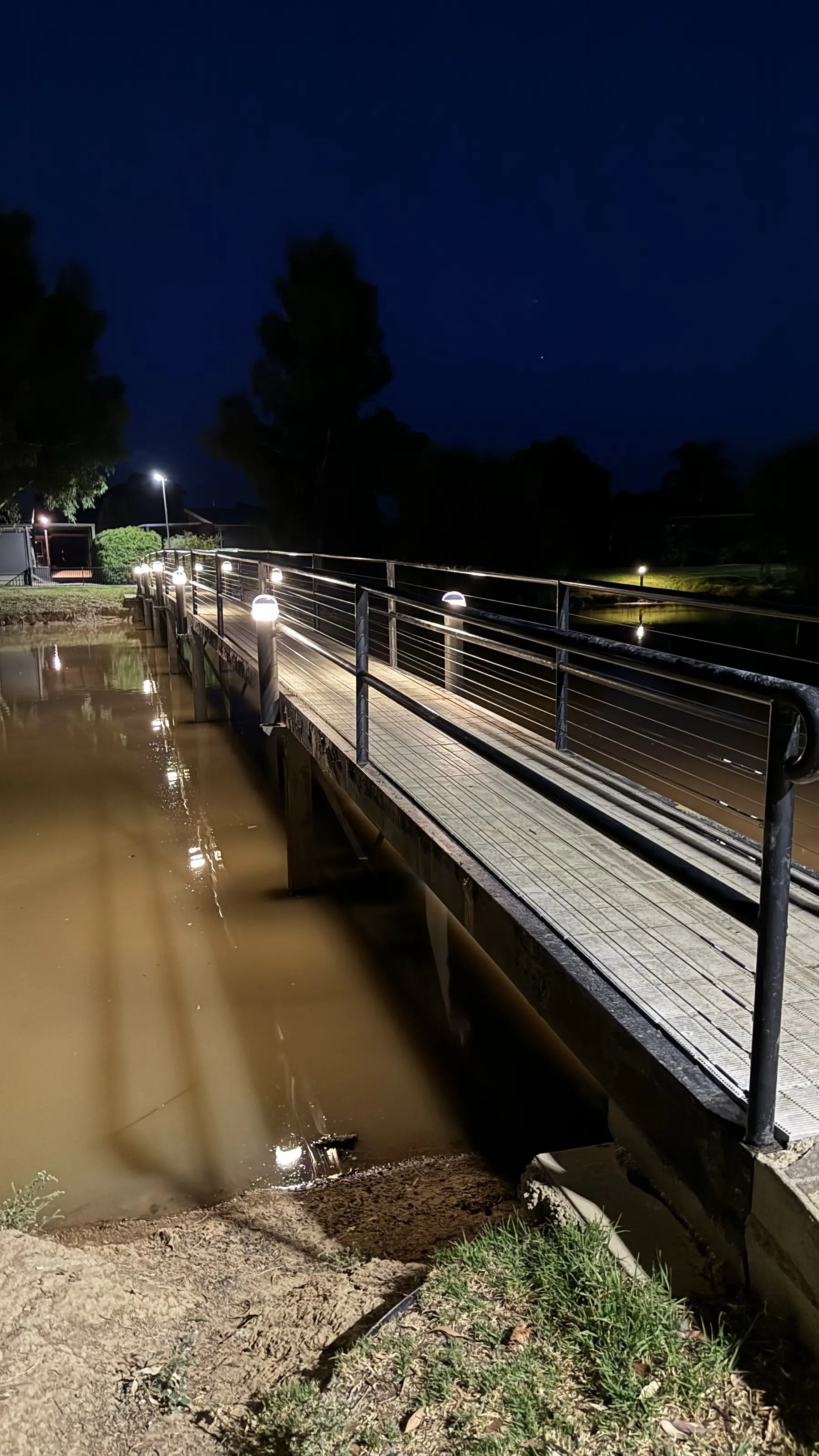 Solar bollards lighting a footbridge over the water at night at Discovery Parks - Moama Waters
